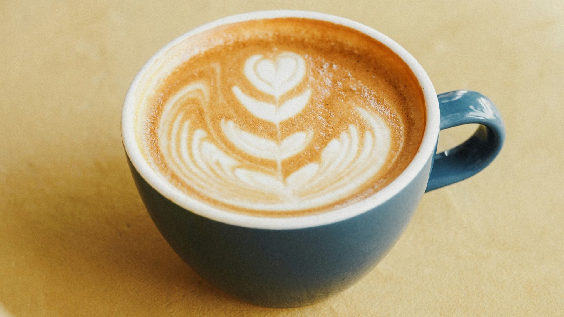 a cup of cappuccino sitting on top of a table