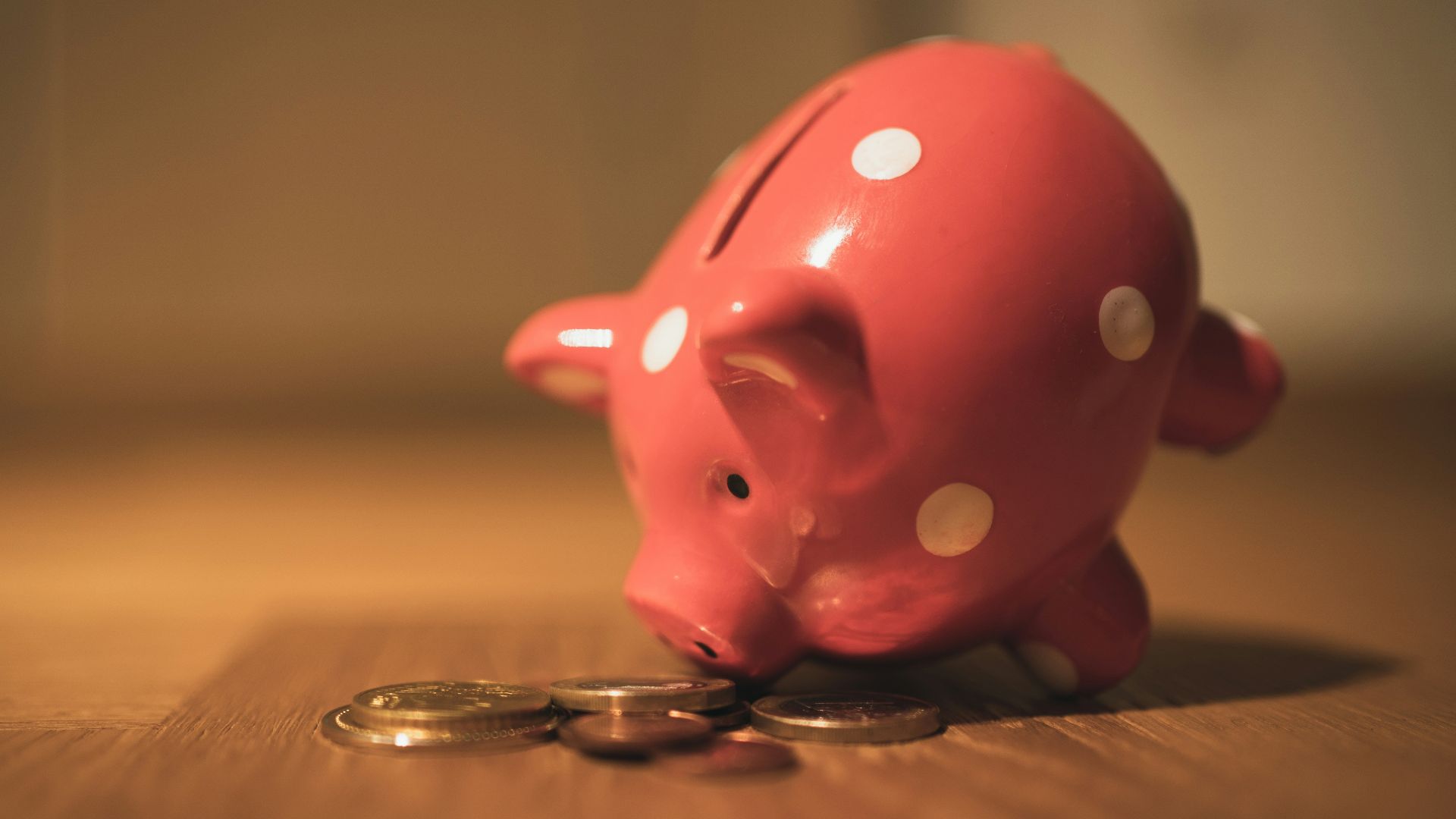 pink pig coin bank on brown wooden table