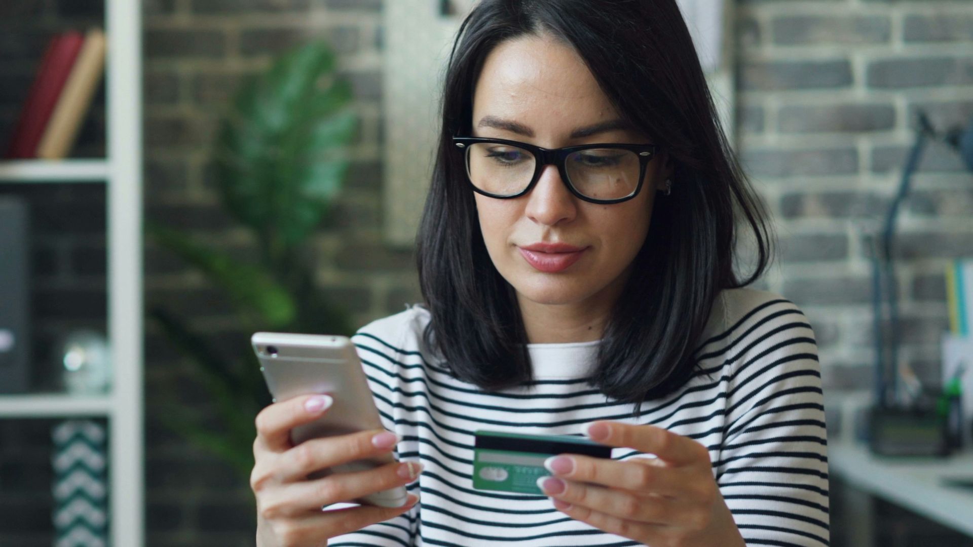 a woman sitting at a table looking at her cell phone