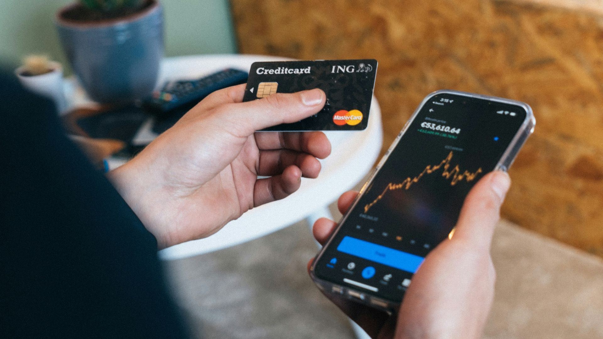 a person holding a smart phone and a credit card