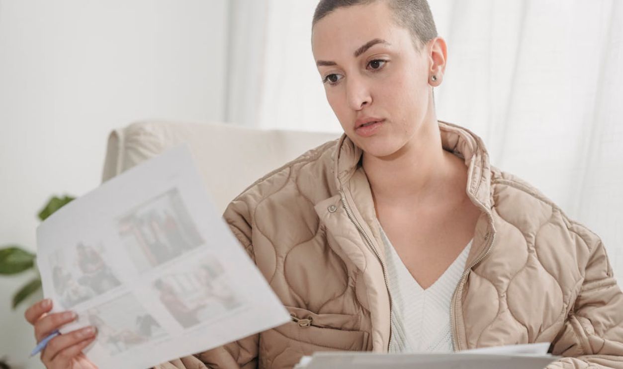 Woman in Brown Bubble Jacket looking at Paper