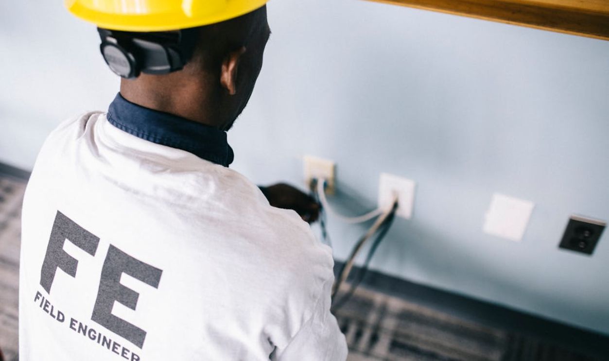 An Electrician Repairing the AC Power Plugs and Sockets