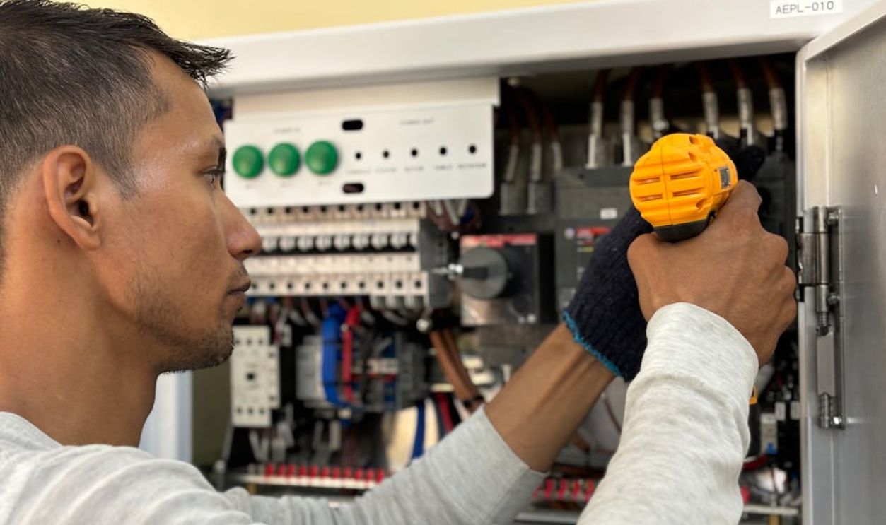A man is working on an electrical panel