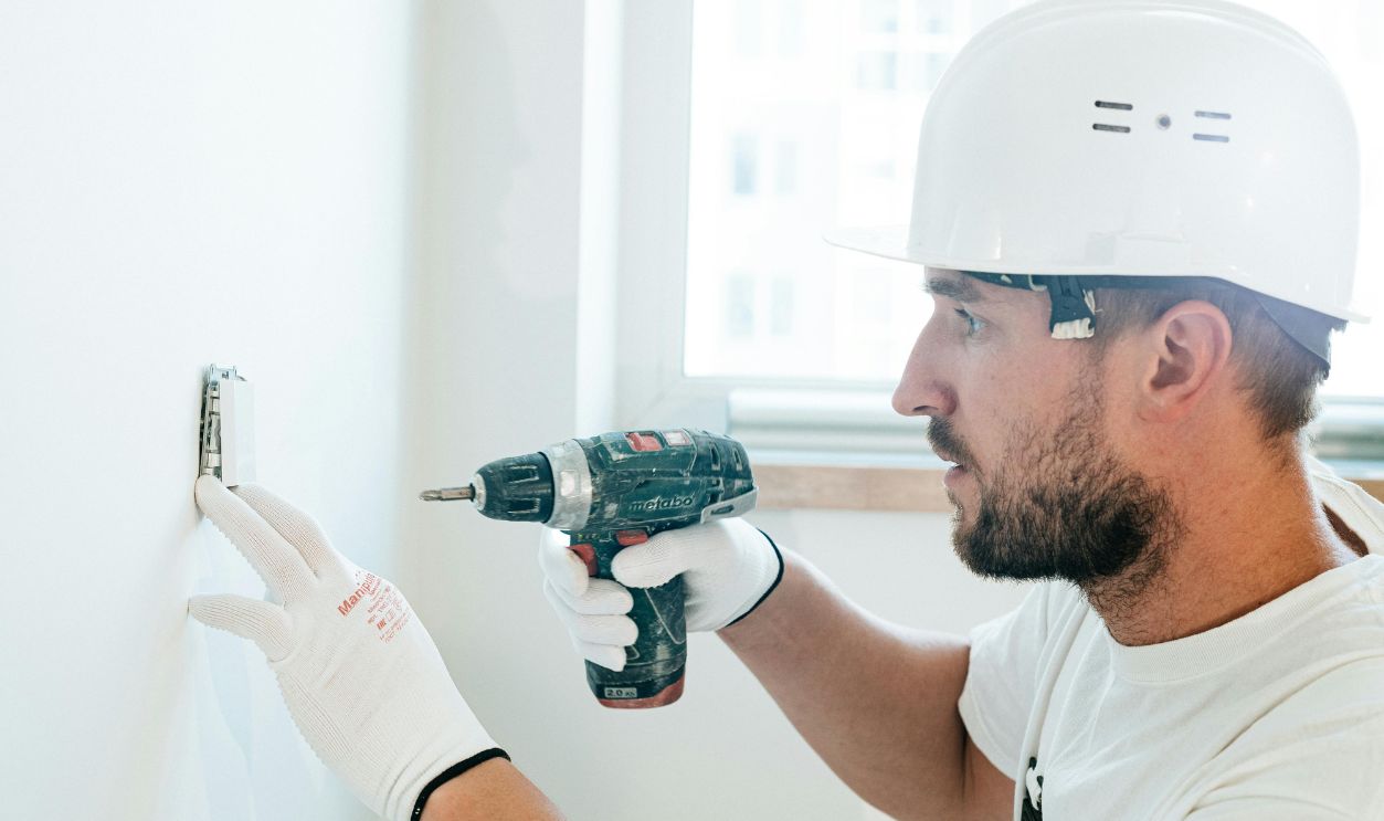 A Man Wearing Safety Helmet using Power Tool