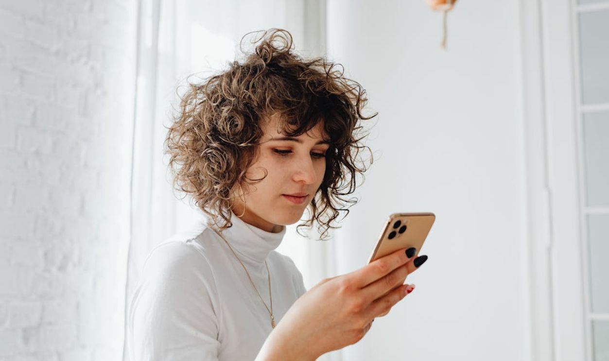 Woman in Turtleneck Shirt Using a Cellphone