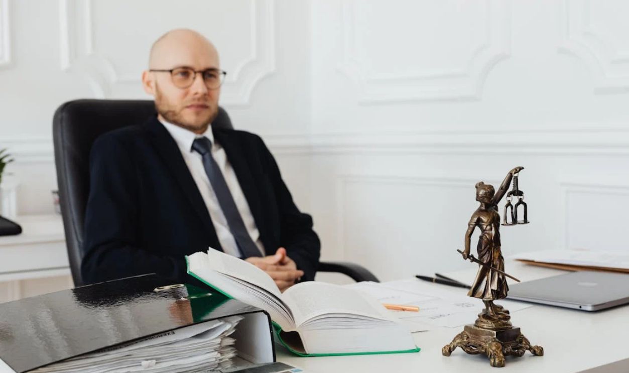 Bald Man Sitting Wearing Eyeglasses and Black Suit