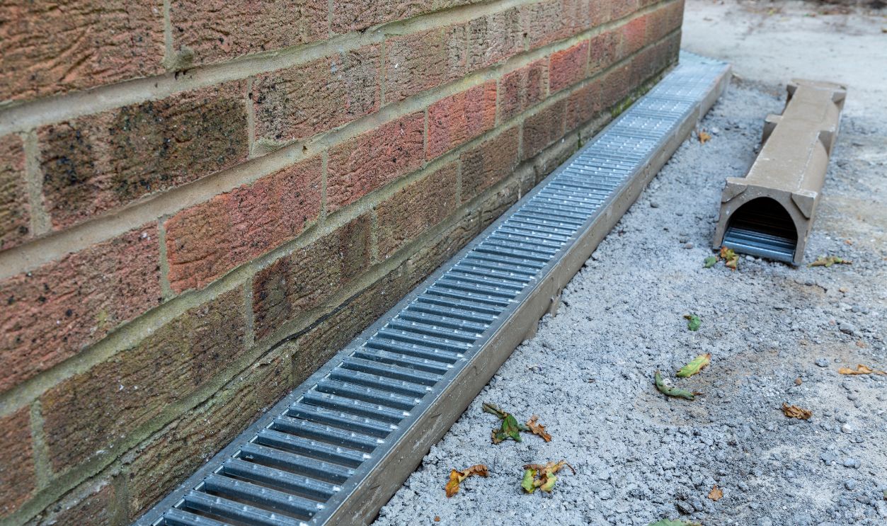 A channel drain being installed as part of a new patio installation