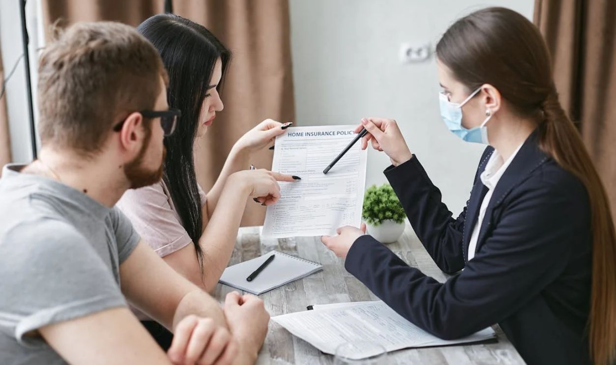 A Woman Explaining a Document to a Couple
