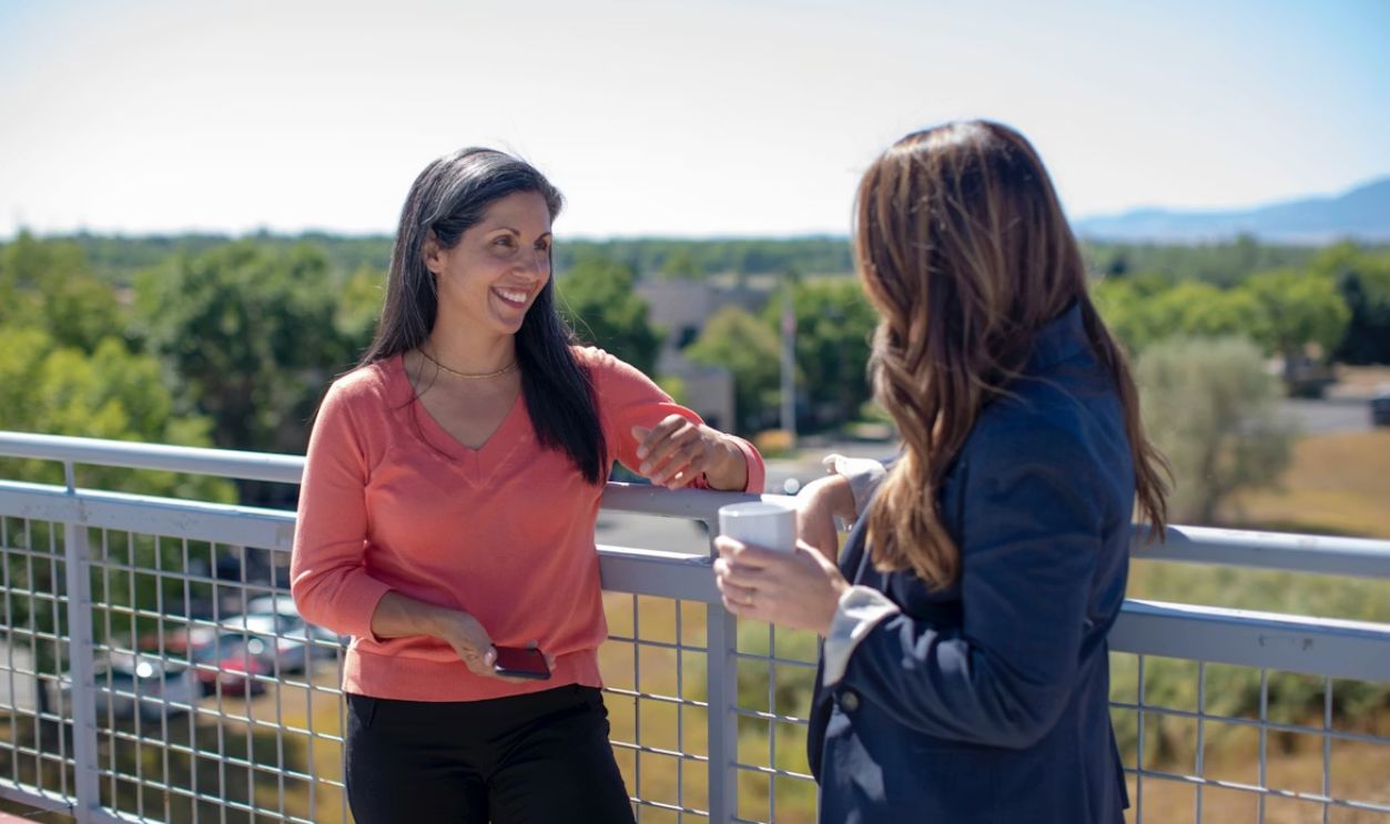 Two business women talking and laughing outside