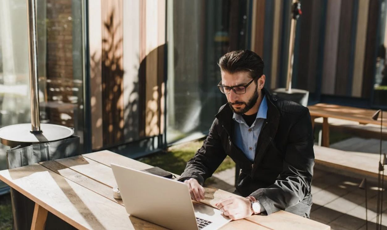 Man at the Table Using Laptop