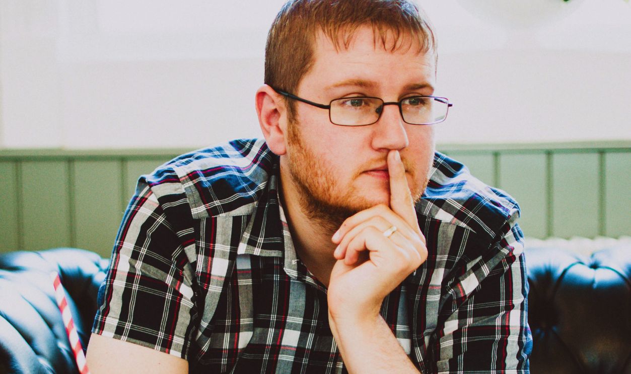 Man Wearing Black Plaid Shirt Sitting