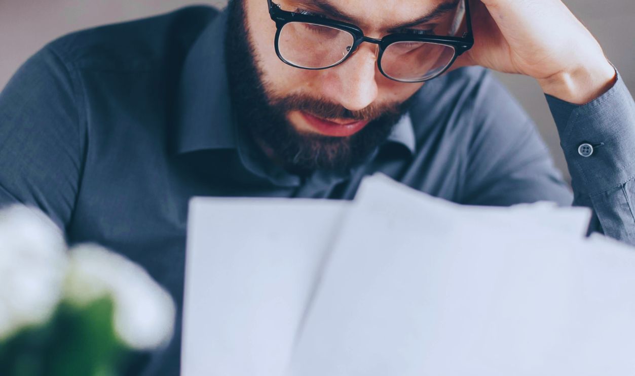 Man in Black Long Sleeve Shirt Holding White Papers