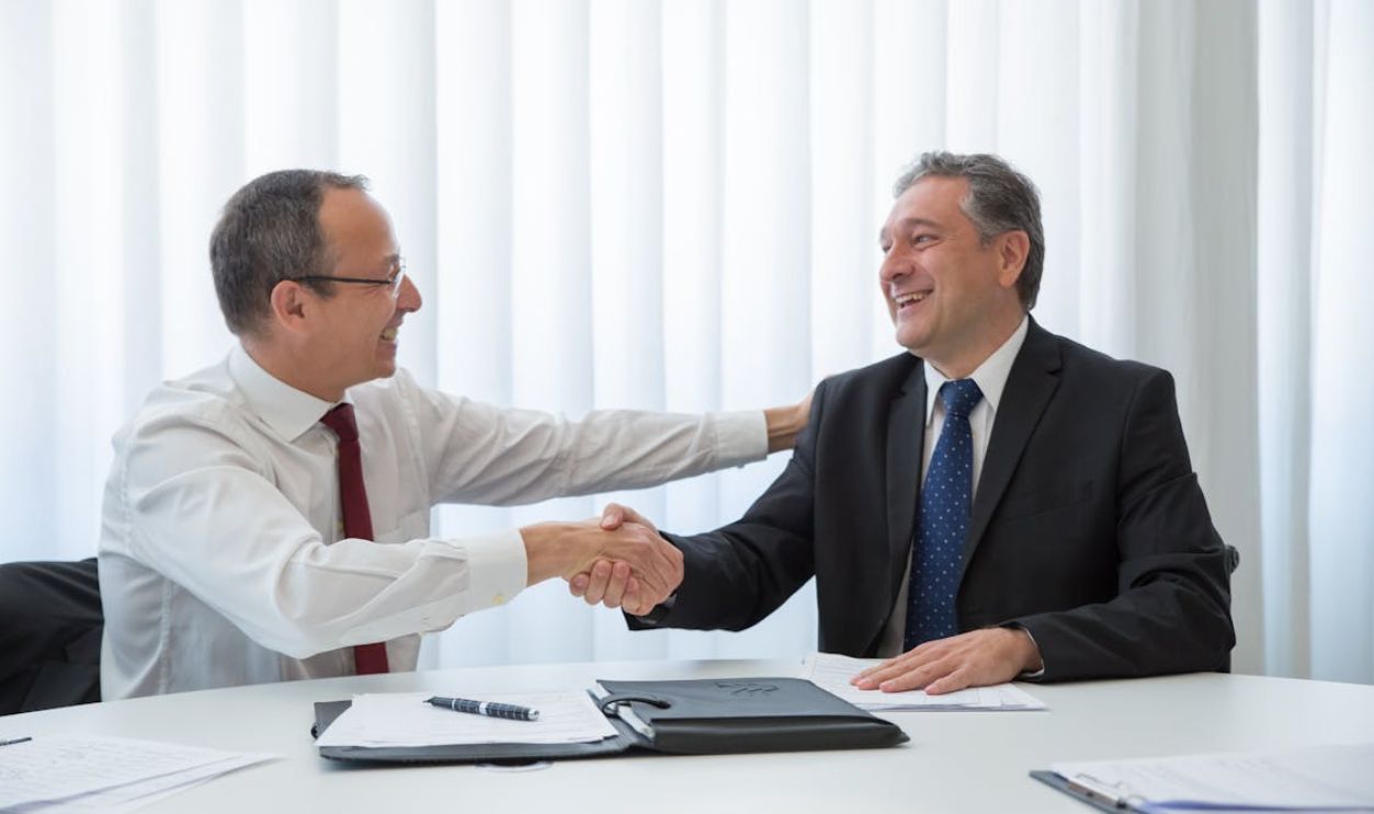 Men Looking at Each Other while Doing Hand Shake