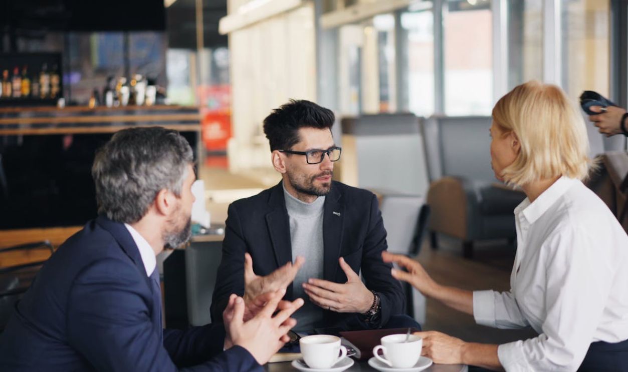 Three people sitting at a table talking to each other