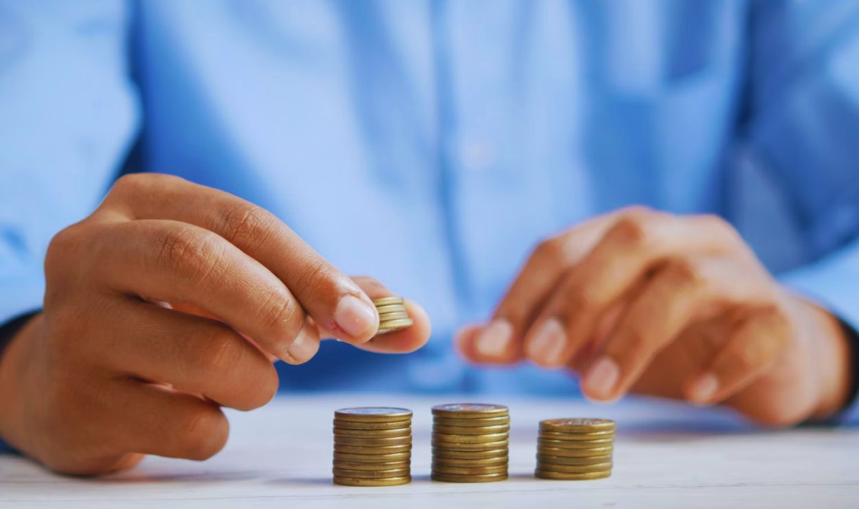 a person stacking coins on top of a table
