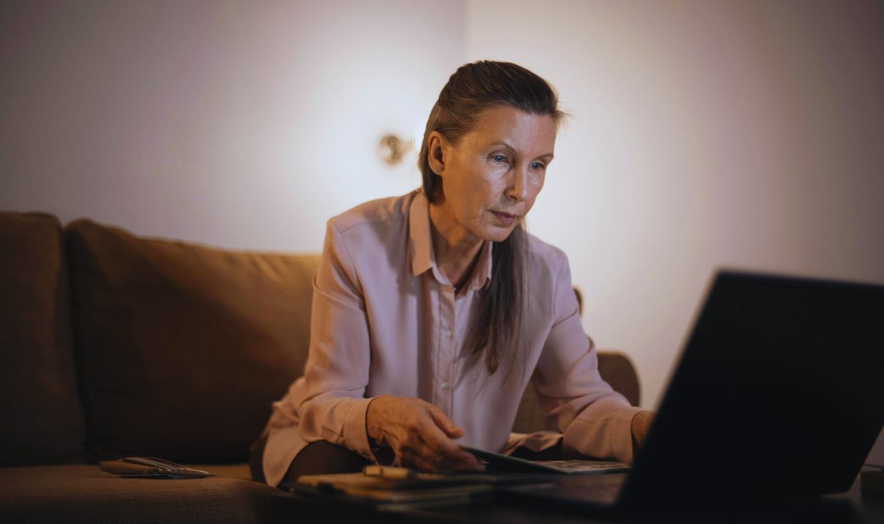 A Woman Sitting at the Table while Using Laptop