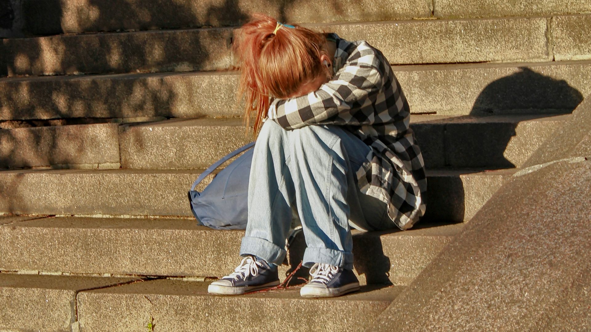 woman in black and white dress sitting on concrete stairs