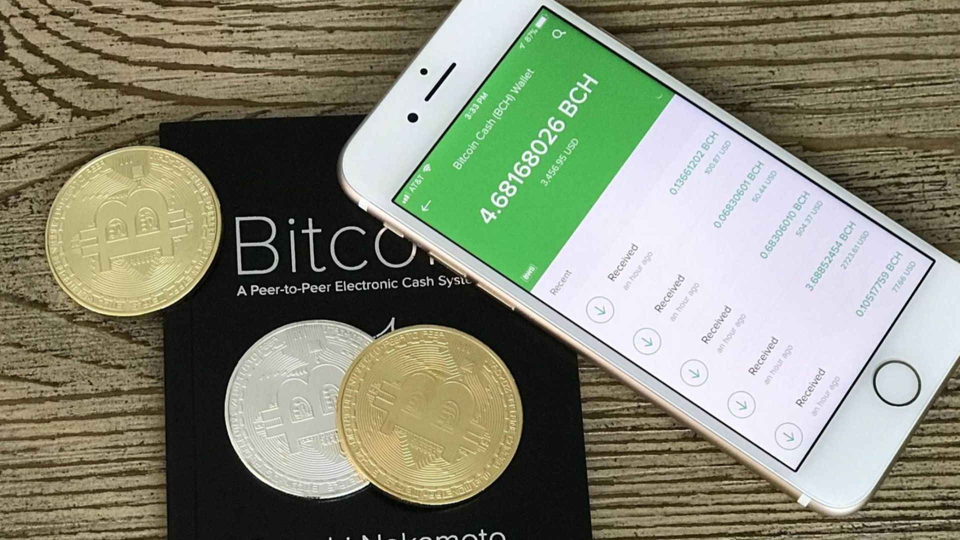 Photo of a mobile phone with a Bitcoin Cash wallet, Bitcoin whitepaper by Satoshi Nakamoto and Bitcoin.com pen