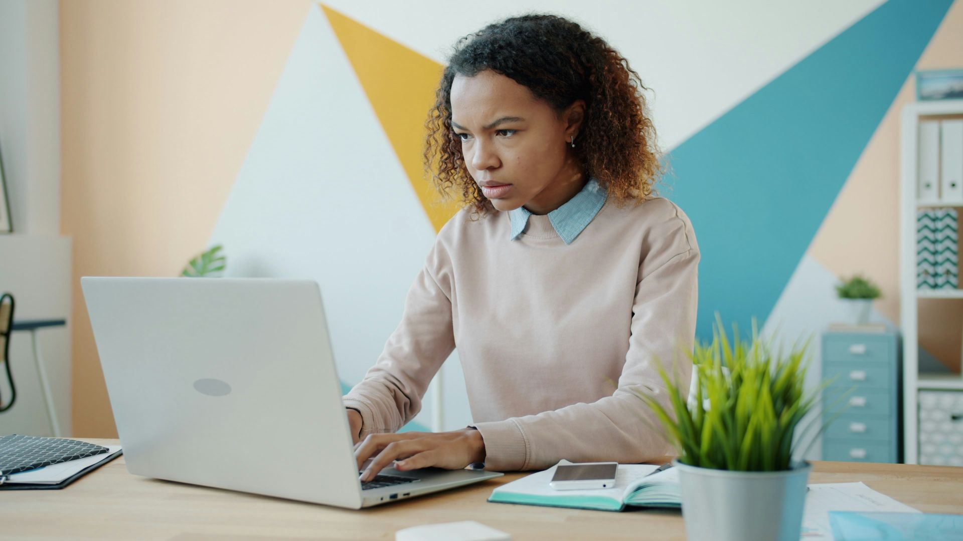 Young woman concentrating while working on a laptop.