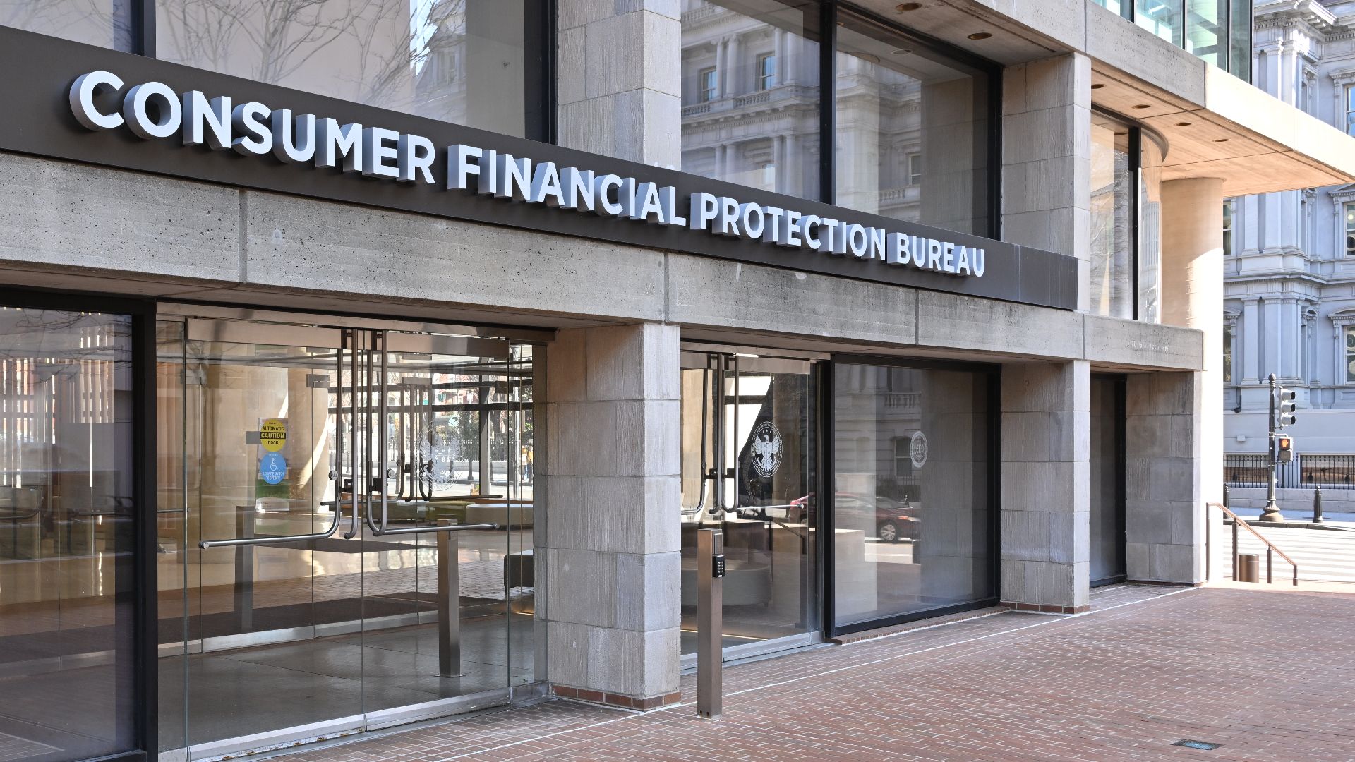 The entrance to the Consumer Financial Protection Bureau headquarters with the bureau's name above it. 1700 G Street NW, Washington, DC 20552.