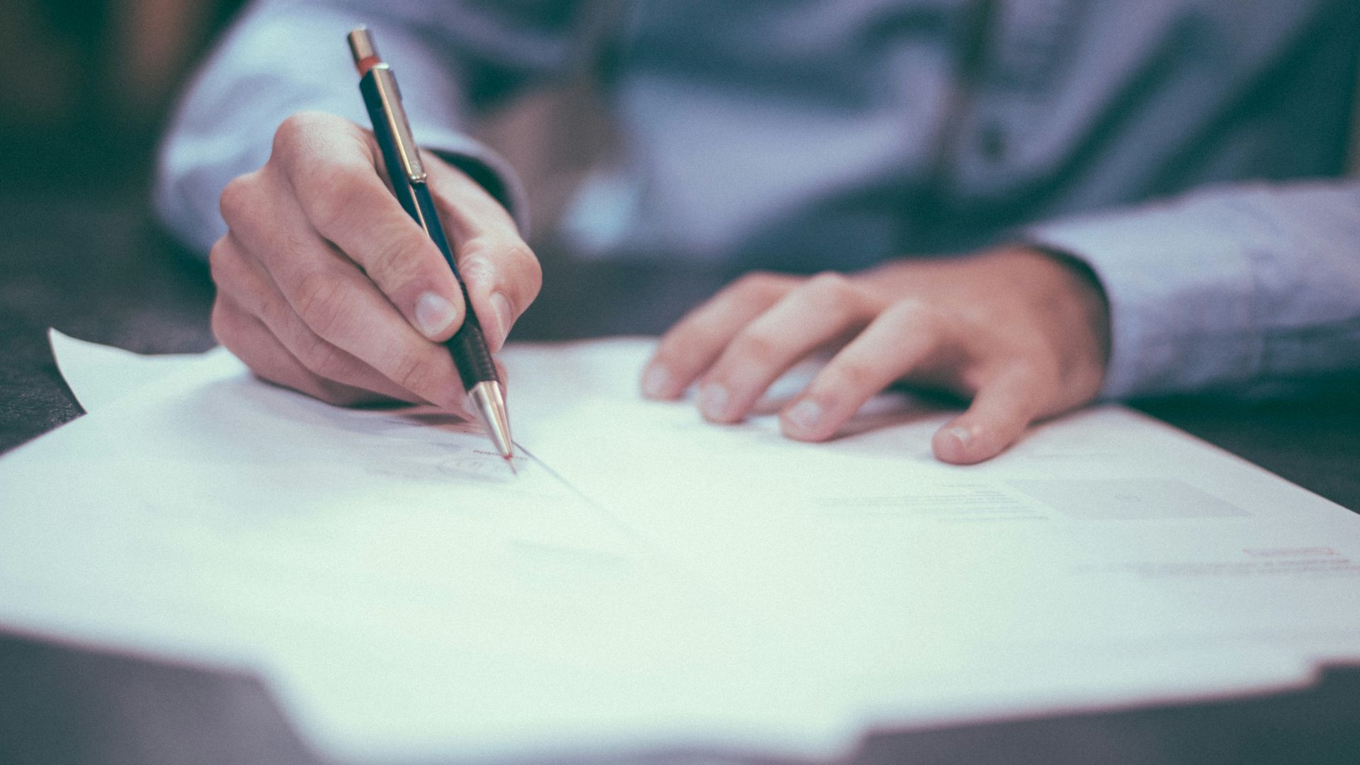 man writing on paper