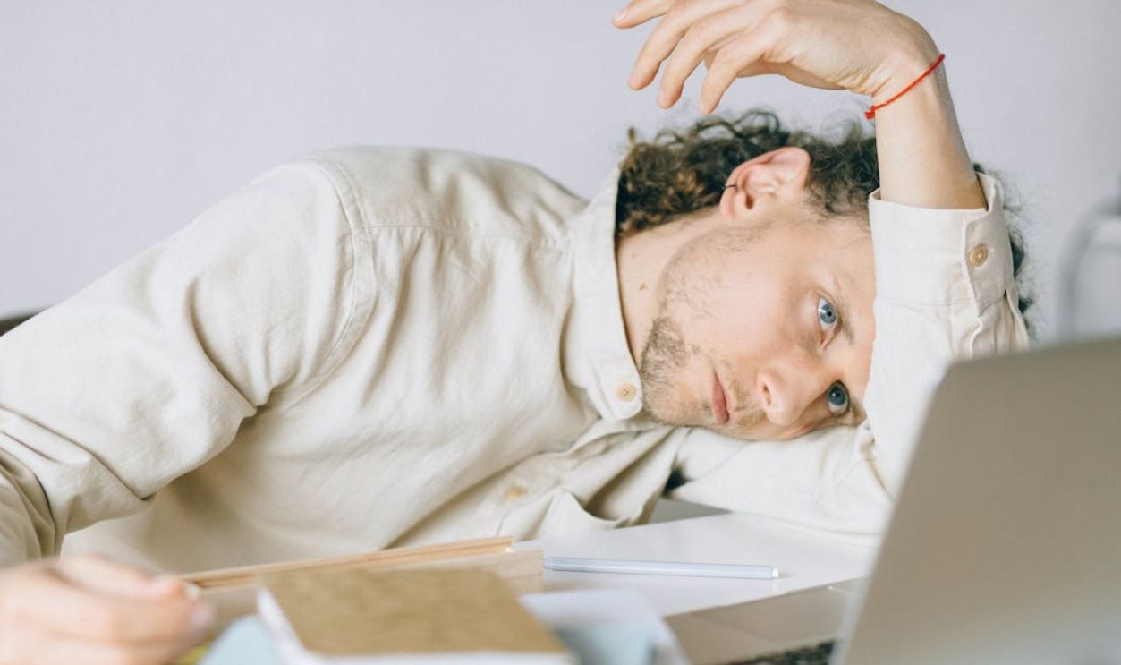 Overworked Employee lying in front of Laptop