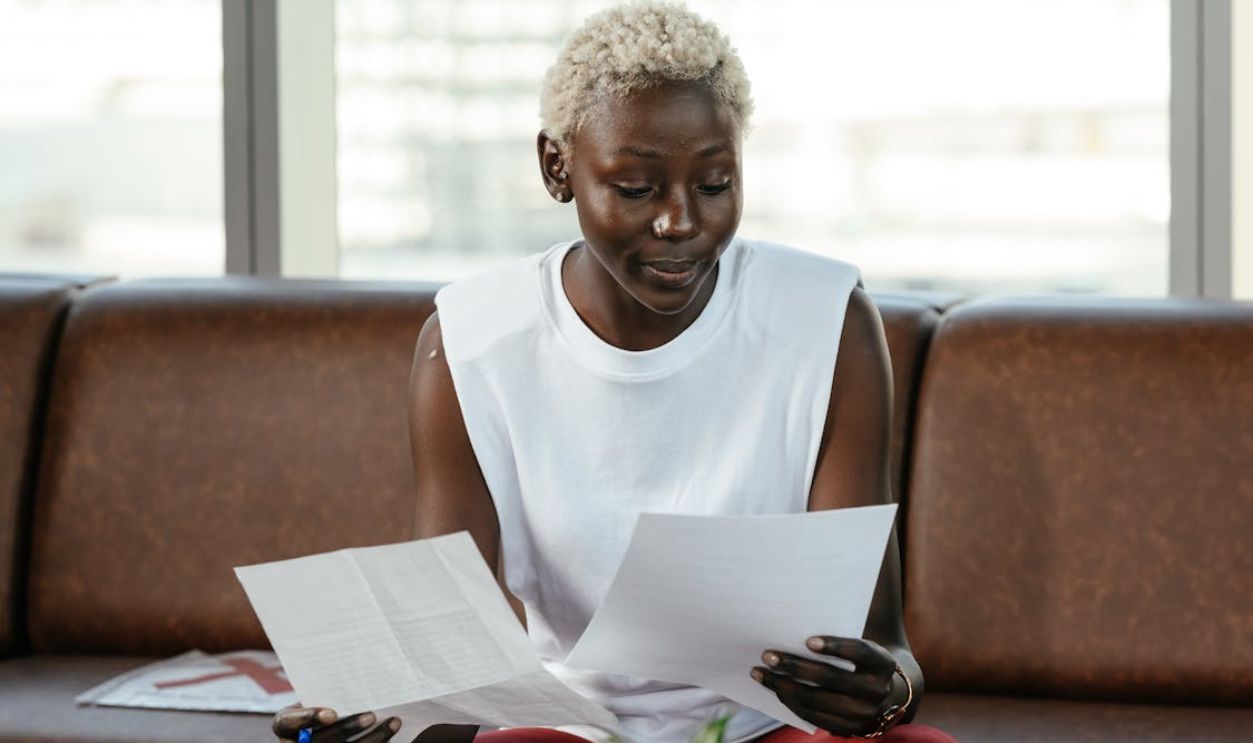 Focused black woman examining documents in office