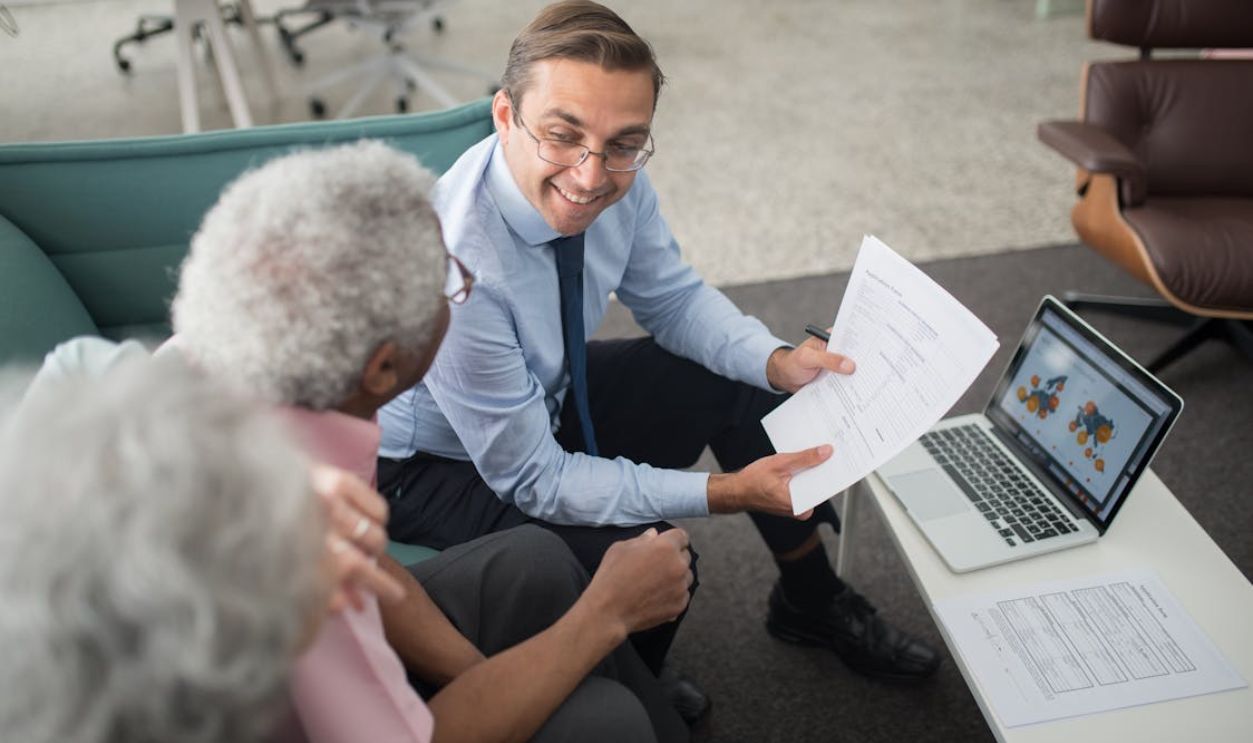 An Agent Showing Documents to an Elderly Man