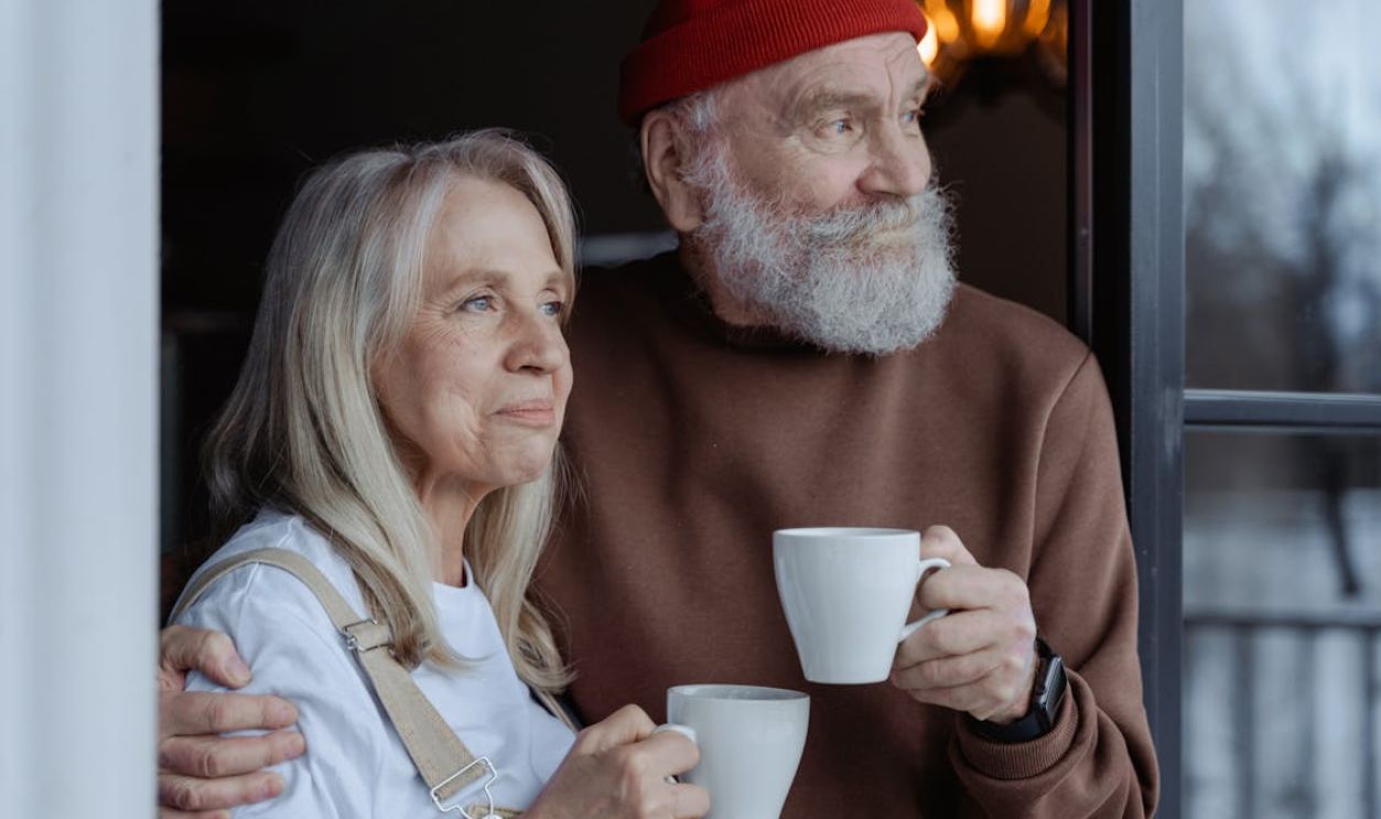 Man and Woman Holding White Ceramic Mugs