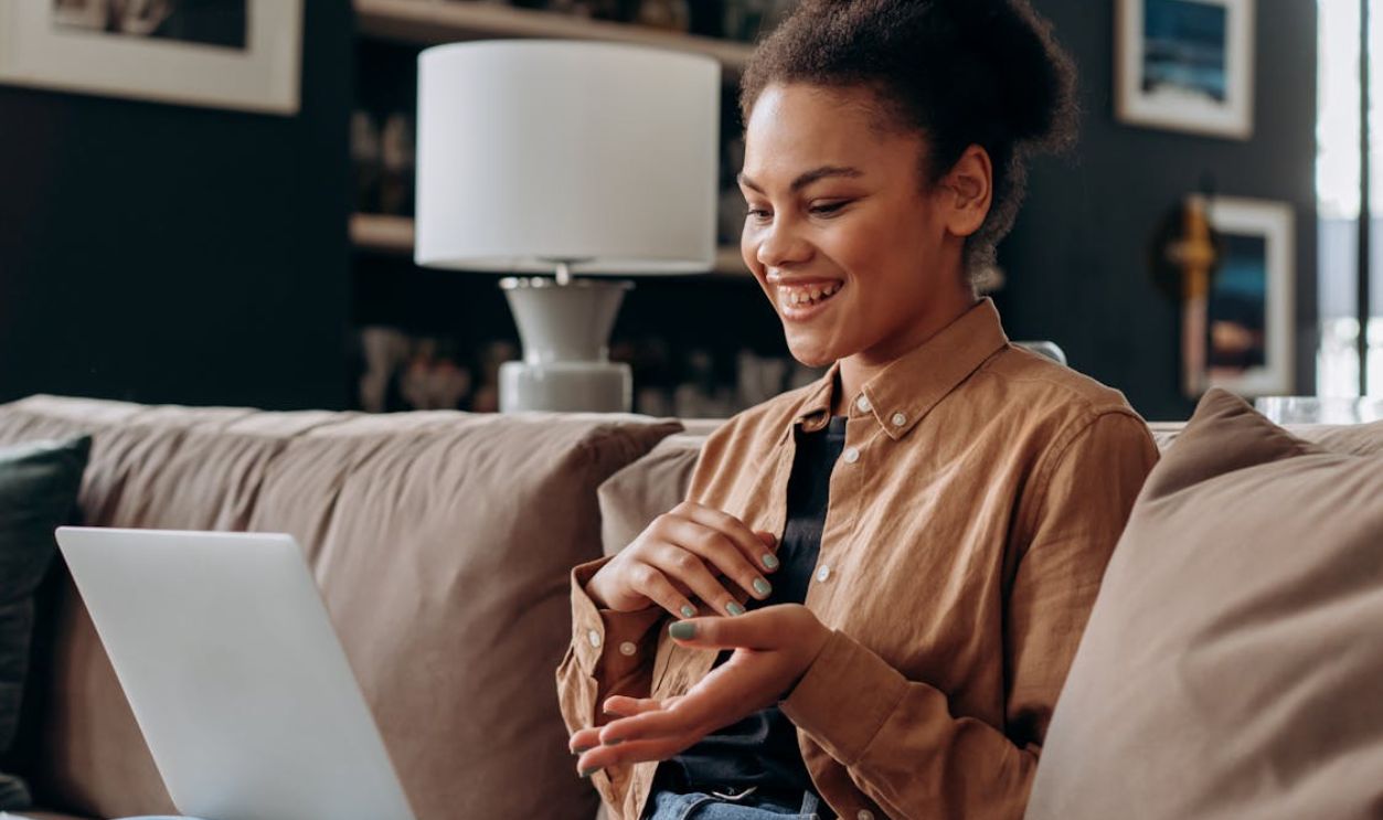 A Woman Smiling While Looking the Laptop