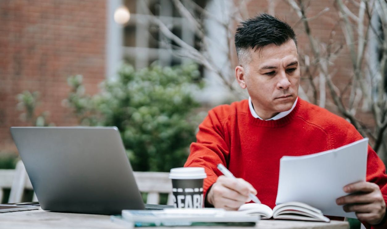 Photo Of Man Writing On Paper