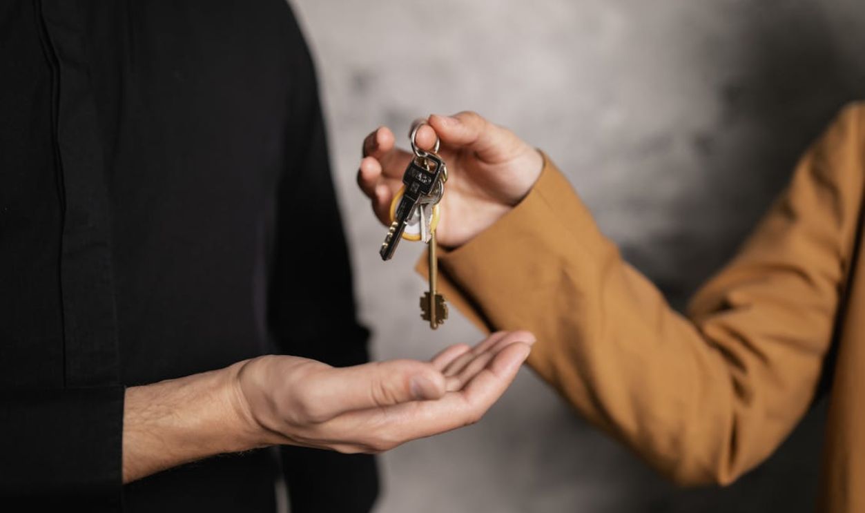 A Person Giving a Bundle of Keys to another Person