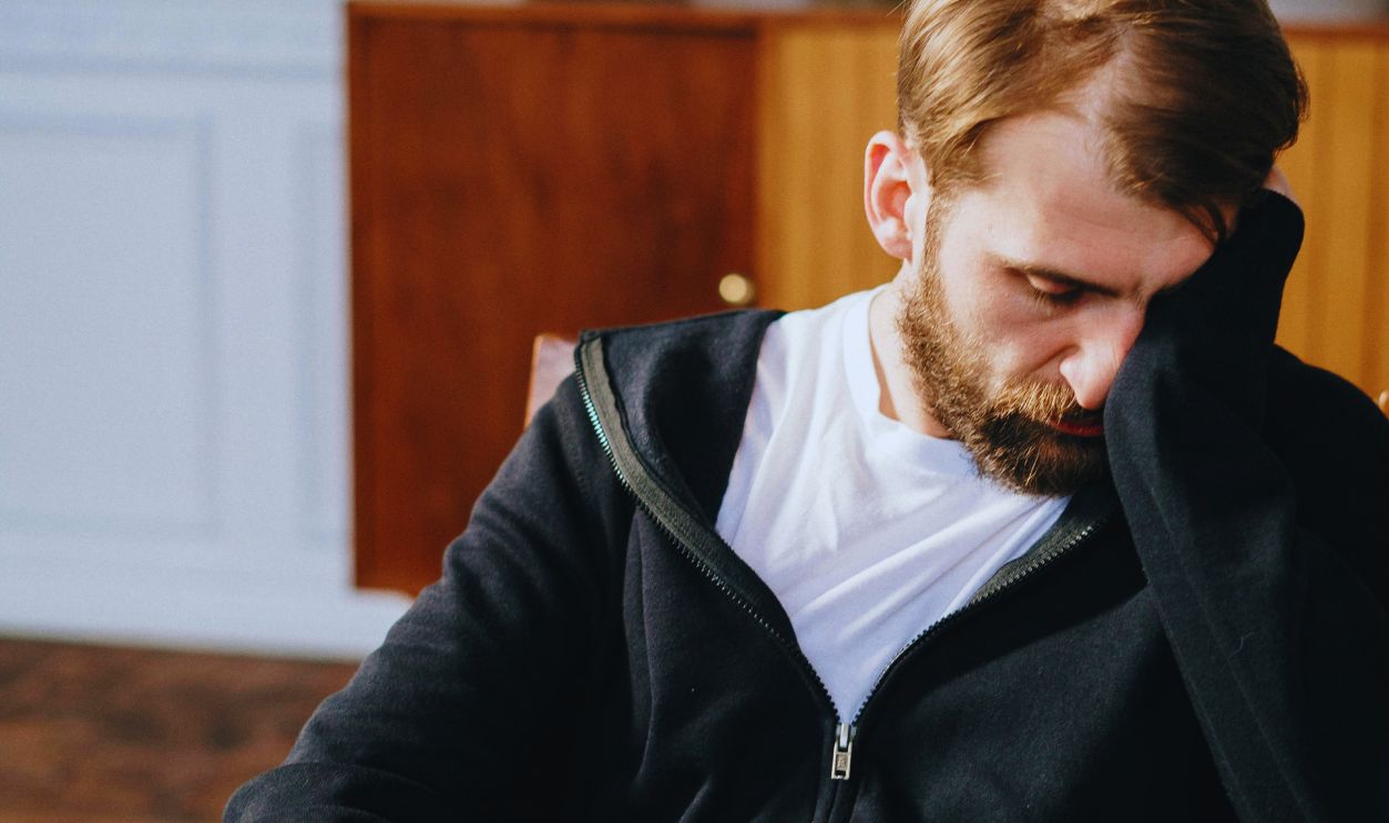 Man in Black Zip Up Jacket Sitting on Chair