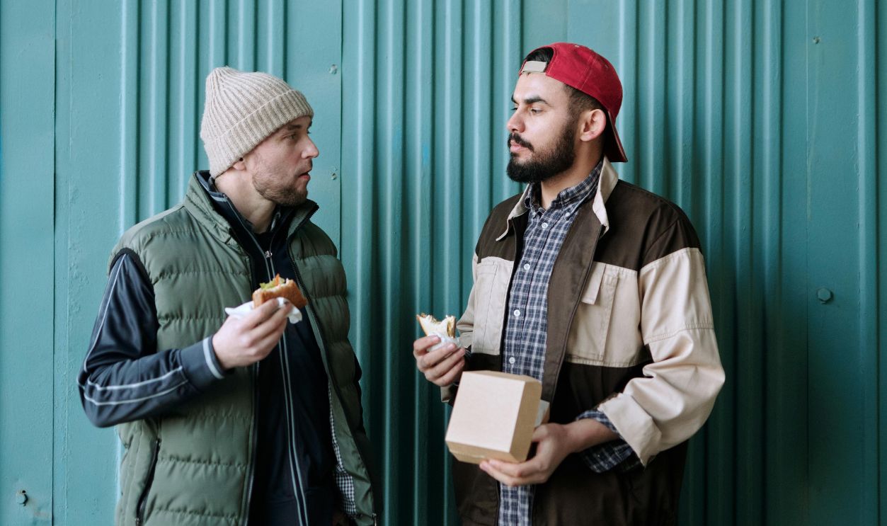 Men Standing Beside Green Wall