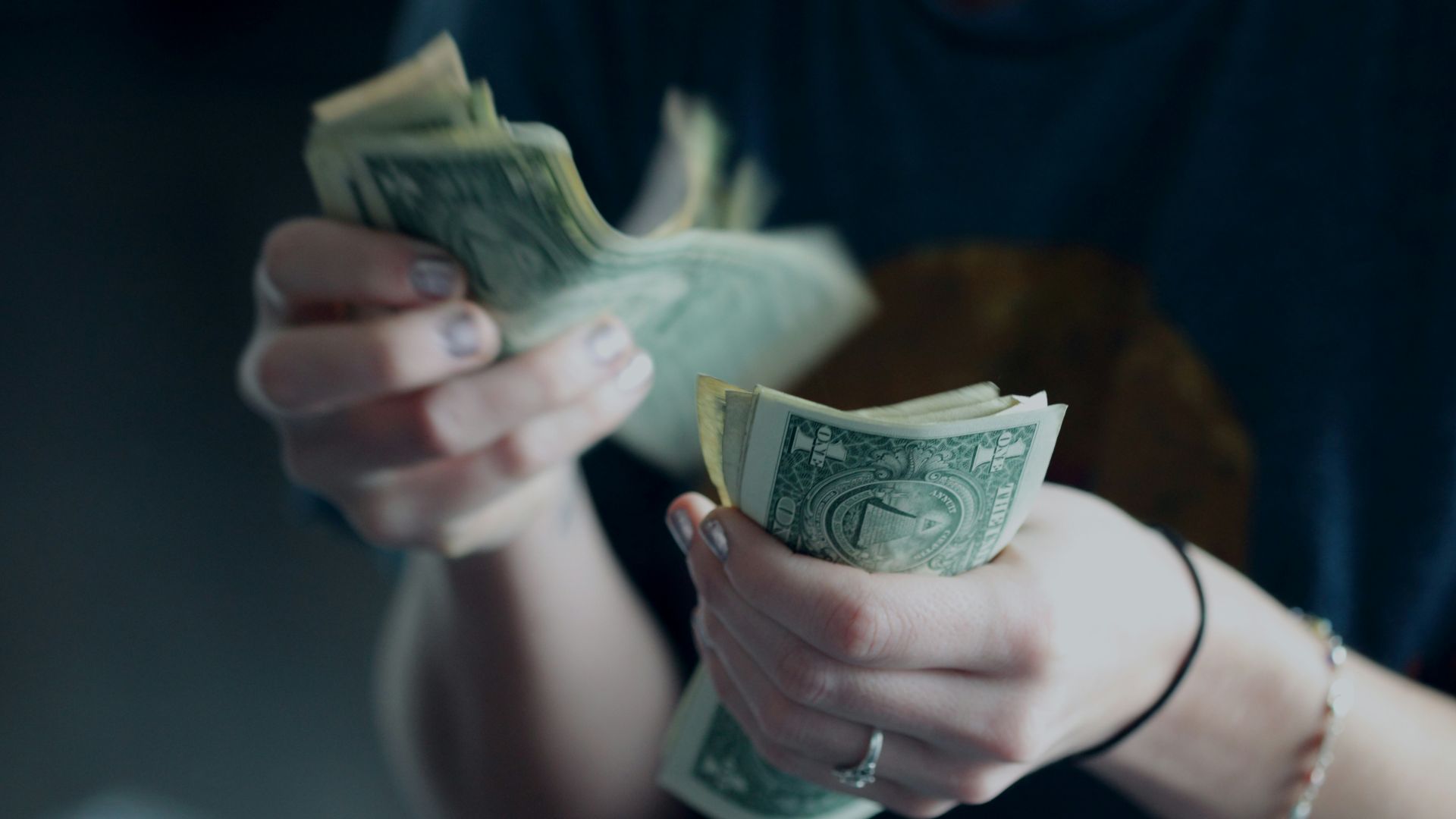 focus photography of person counting dollar banknotes