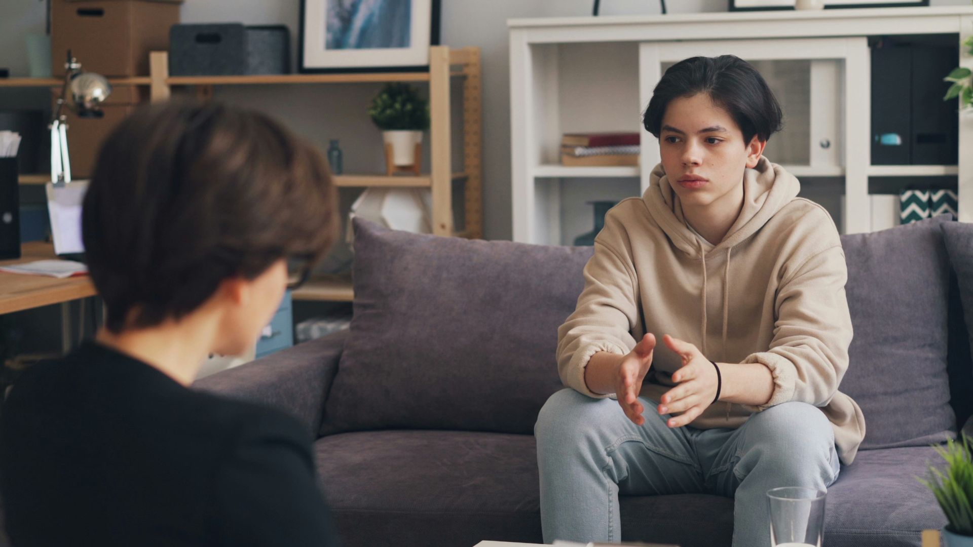 a woman sitting on a couch talking to a man
