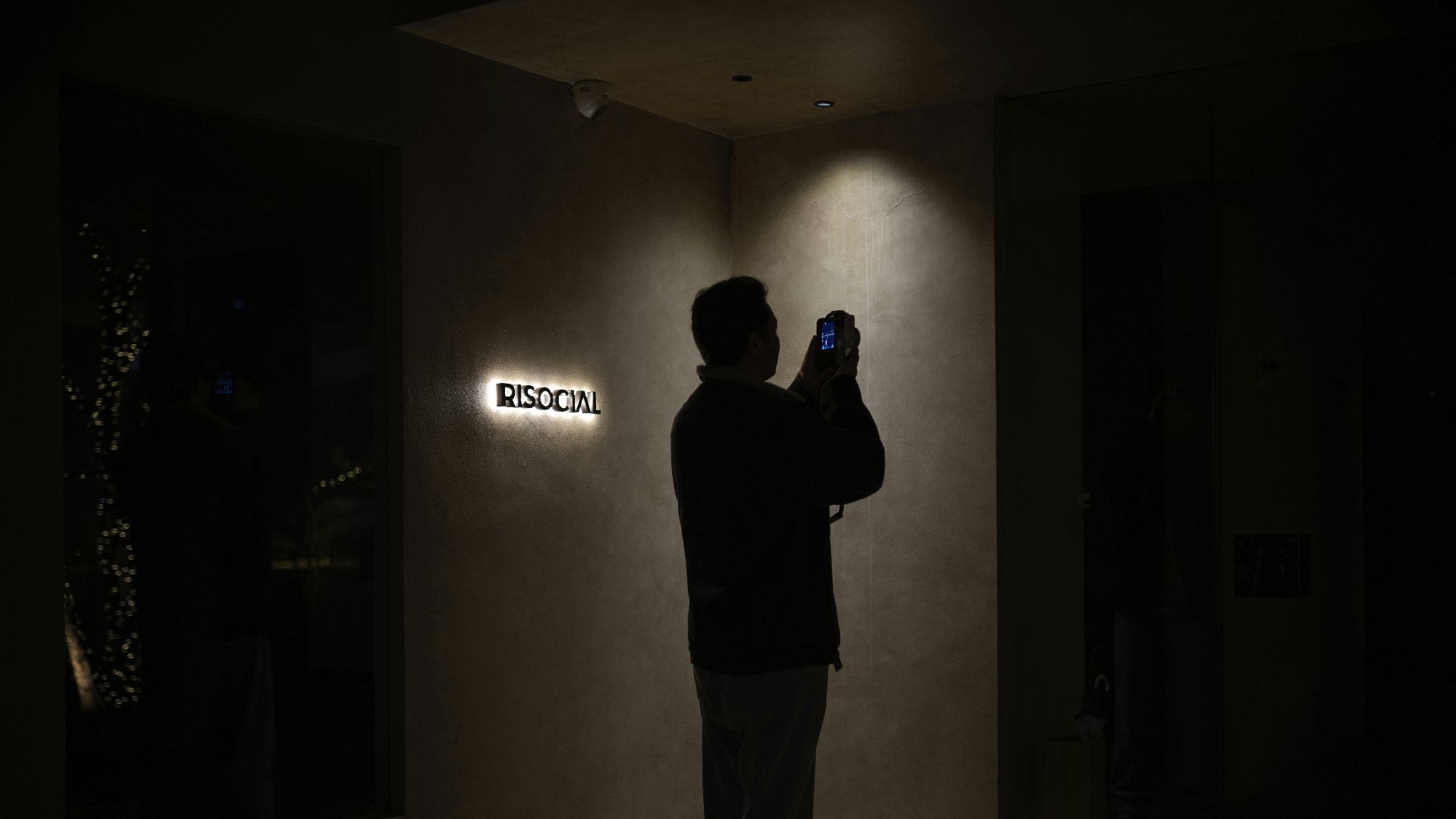 Person silhouetted against a glowing sign at sign.
