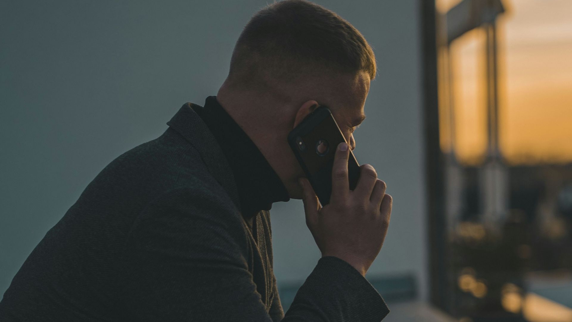 man in black long sleeve shirt sitting by the table