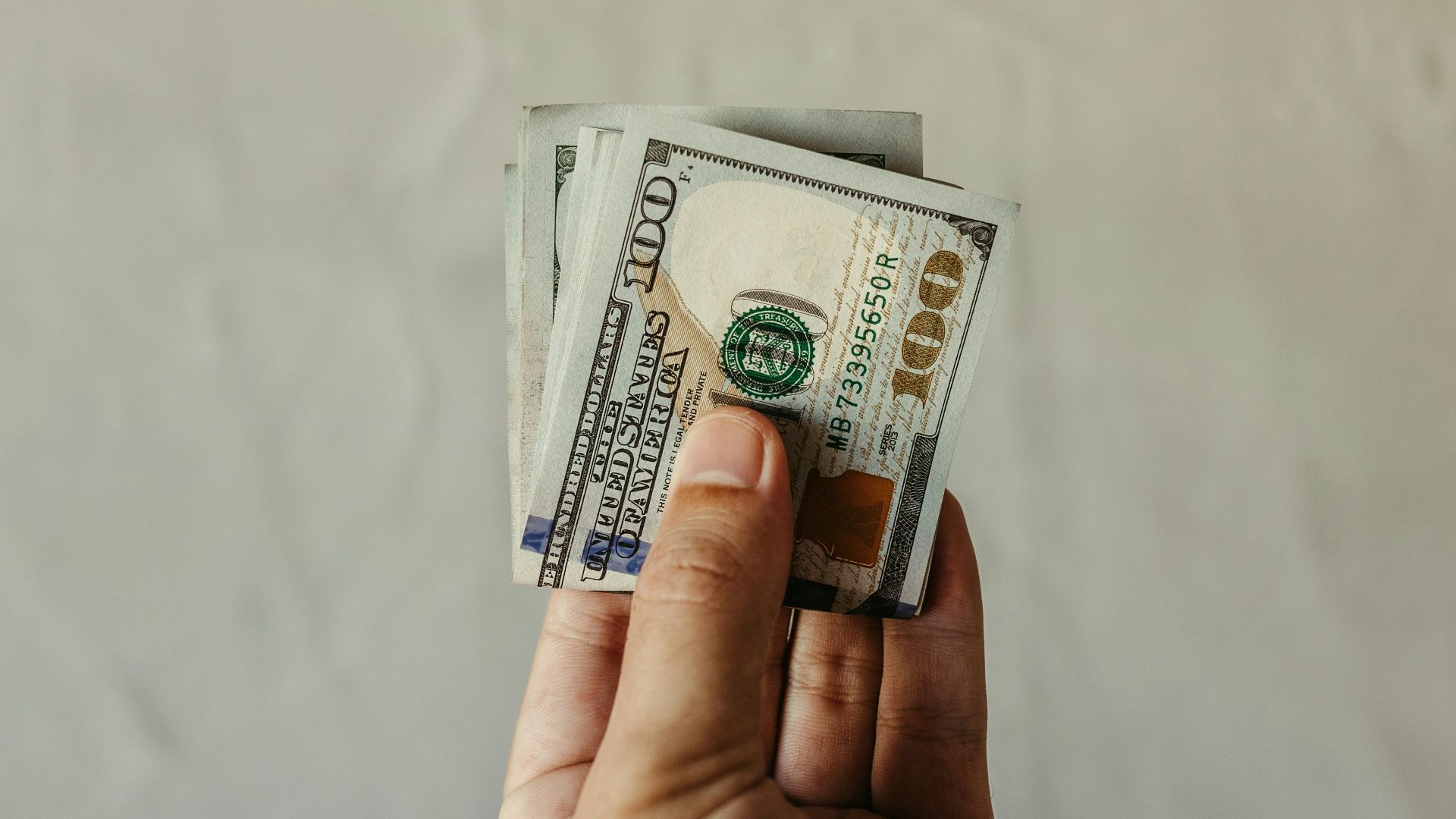 a person holding a stack of money in their hand