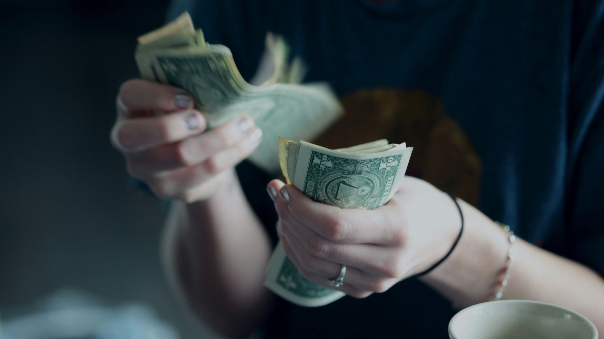 focus photography of person counting dollar banknotes