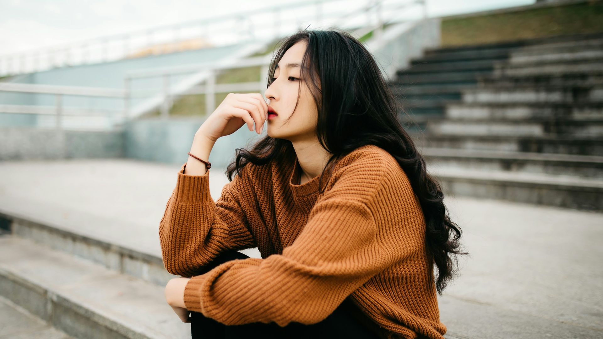 woman wearing brown sweater holding lips