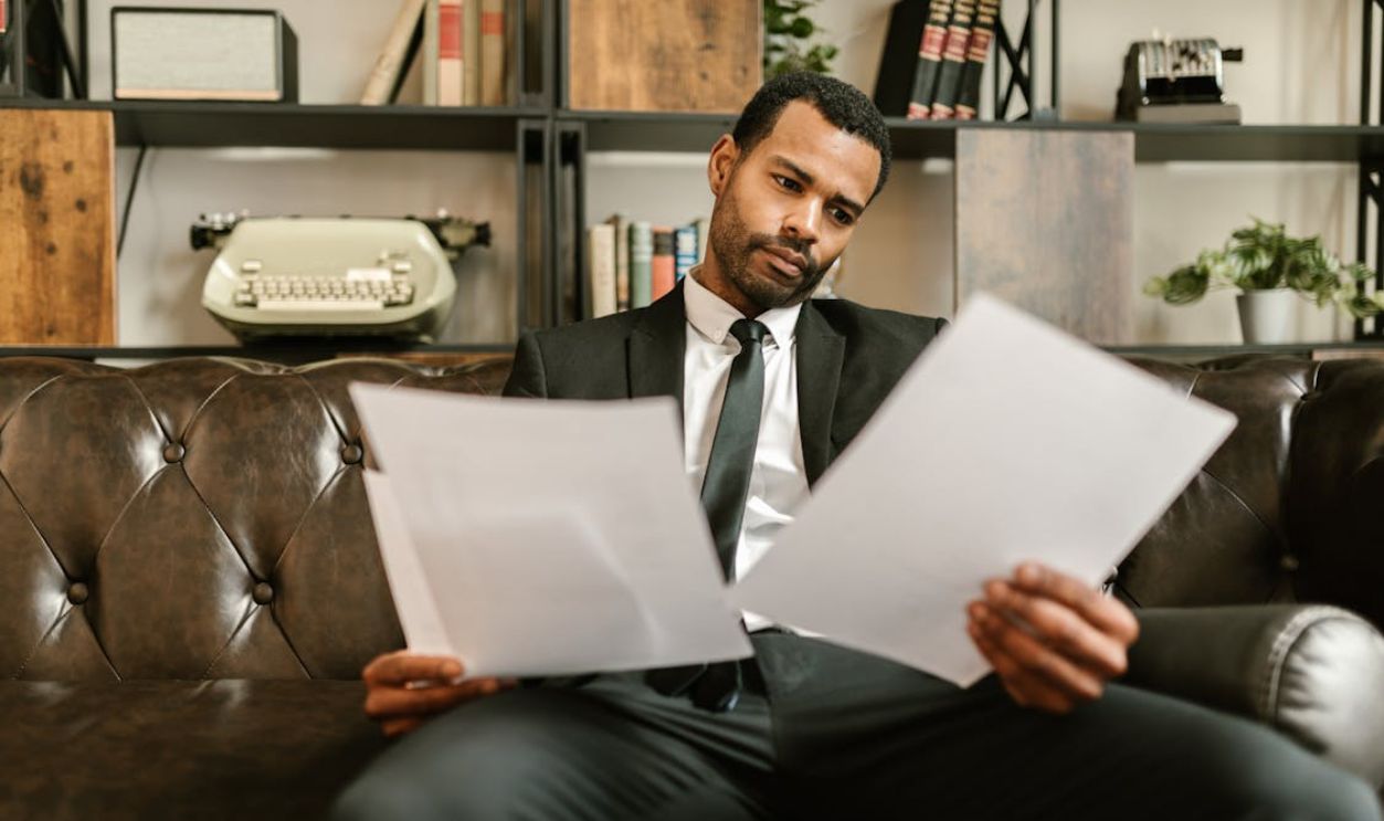 A Man in a Suit Looking at Documents