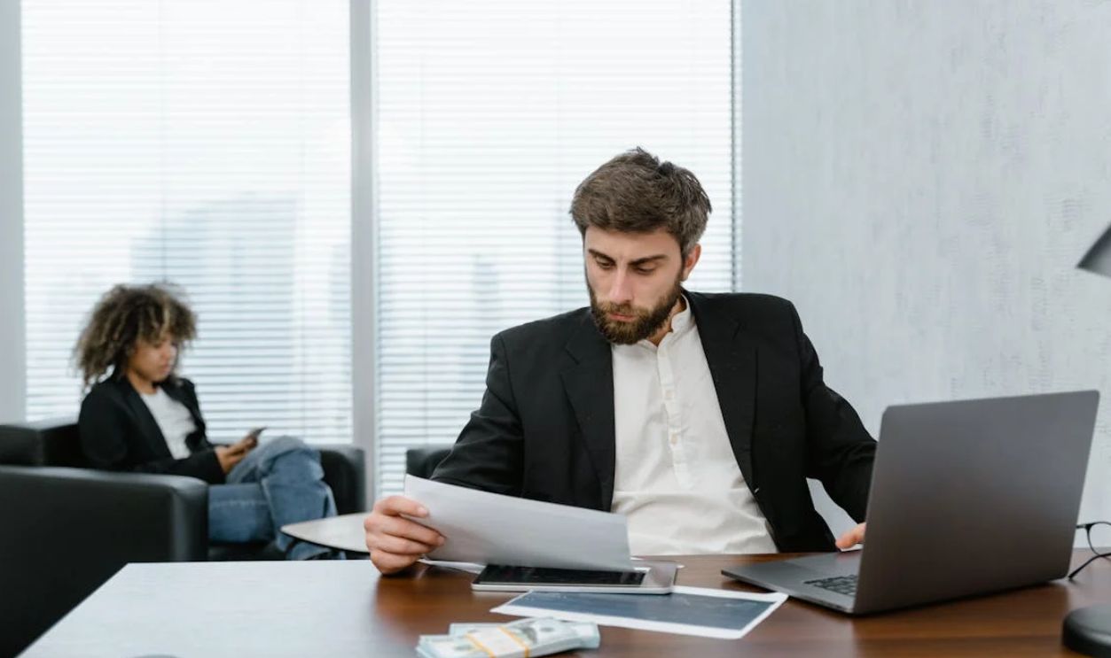 Man in Black Suit Jacket Analyzing Data Reports