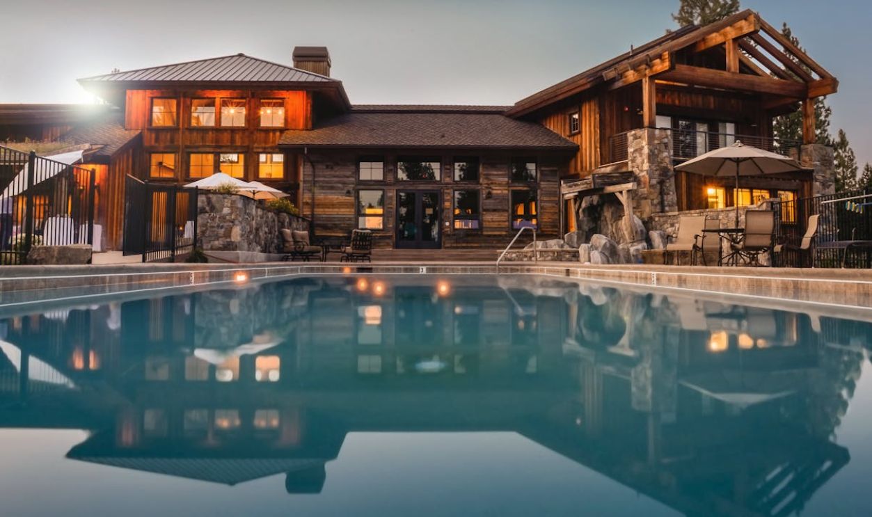 Brown Wooden House Infront of Swimming Pool Under Blue Sky