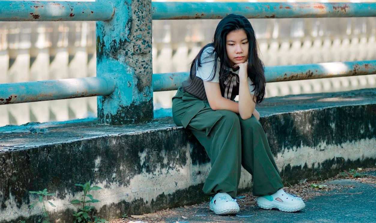 Thoughtful Teenage Girl Sitting Outdoors