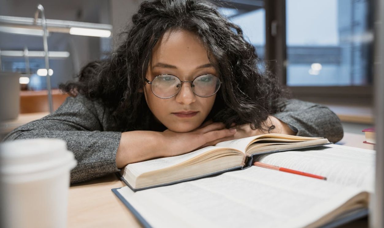 A Woman Wearing Eyeglasses Resting her Chin on her Hands