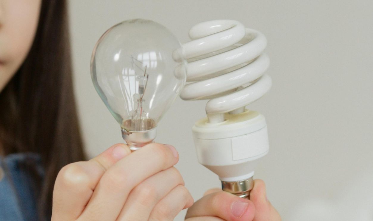 Girl Looking At Two Light Bulbs
