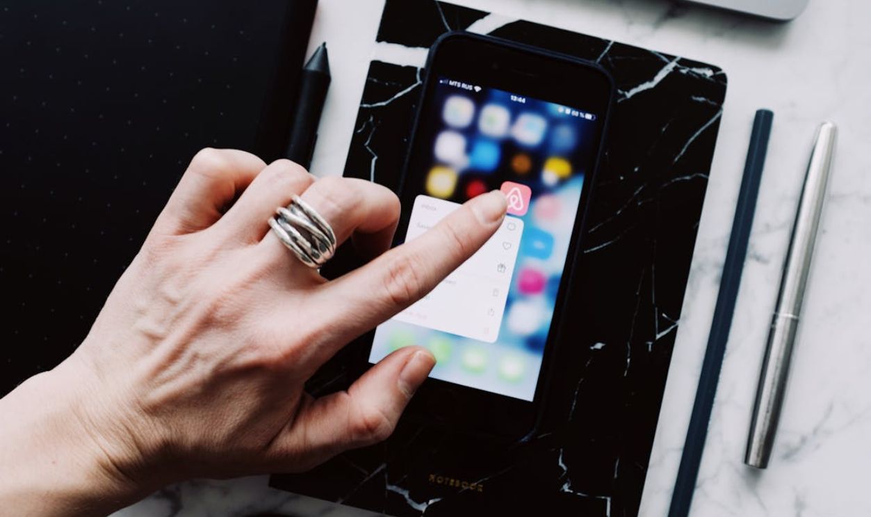 Faceless person using smartphone while working with gadgets at home