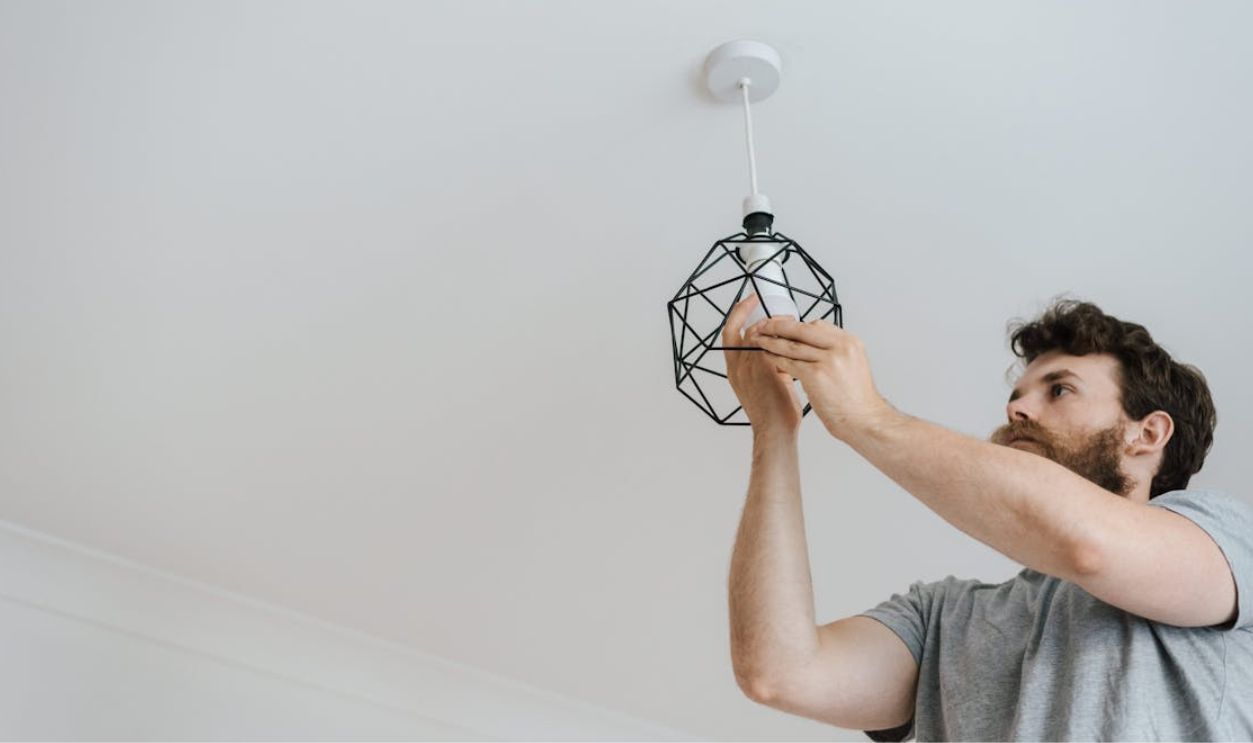 Man screwing light bulb into lamp