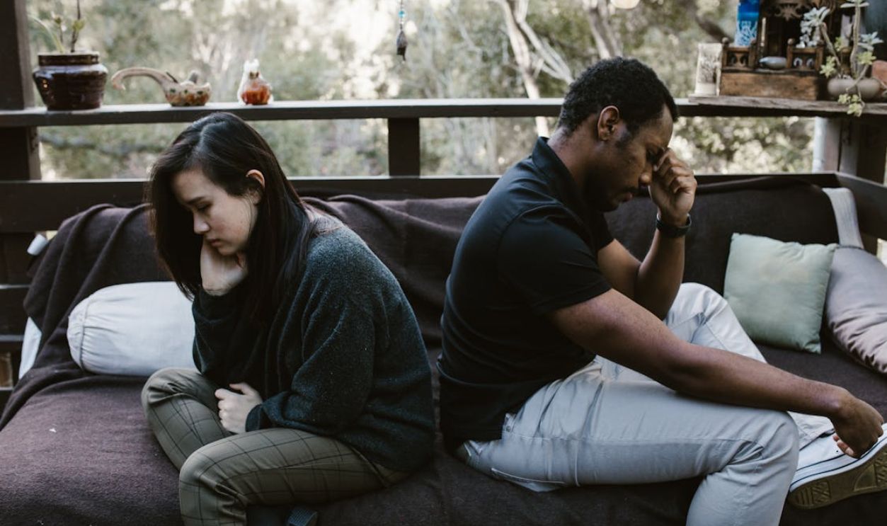 Man and Woman Sitting Back to Back